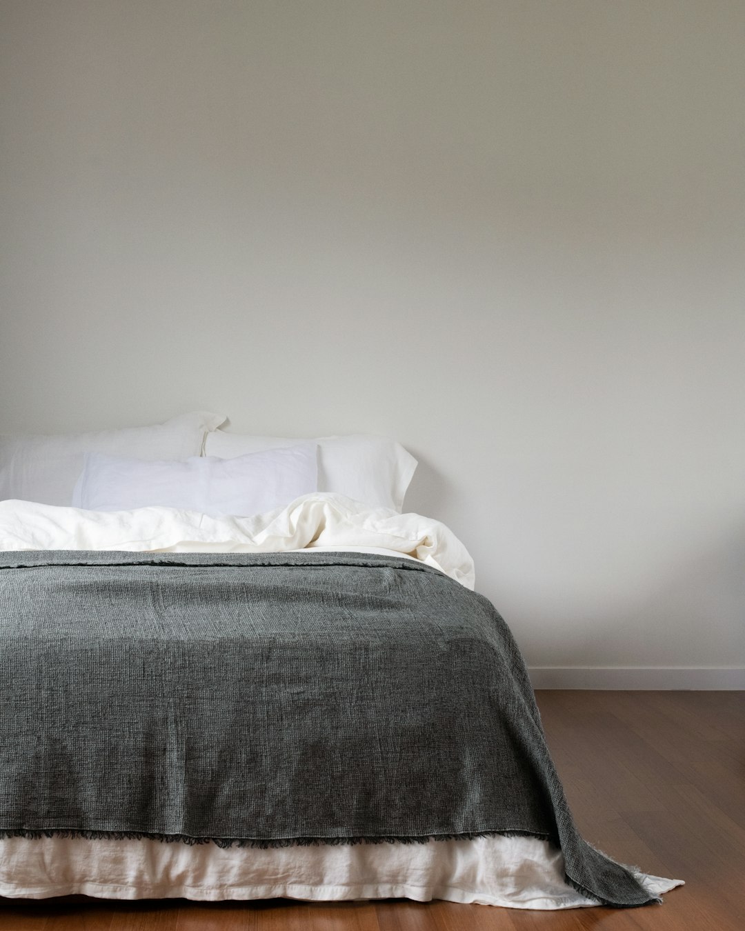 why-choose-us a-neatly-made-bed-with-a-grey-blanket-8jdh4fnqvri